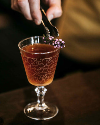 Pinnacles Park cocktail in small glass with thyme sprig