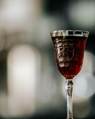 Three Crossing cocktail in cocktail glass in front of blurred background