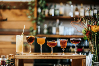 Brucato Amaro cocktails arranged in a line on a bar