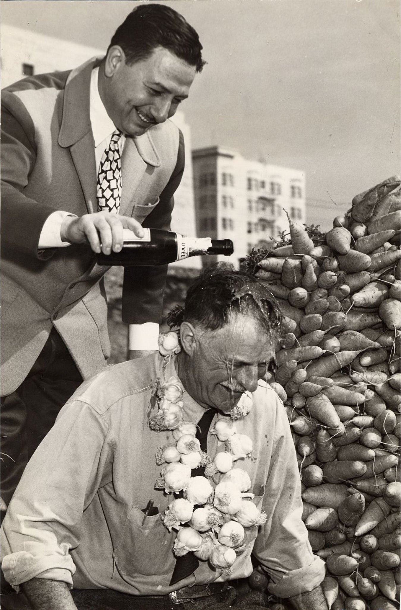 John Brucato pouring champagne on laughing friend